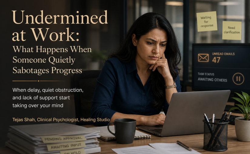 Indian professional feeling undermined at work while facing subtle workplace sabotage in an office setting — Tejas Shah | Healing Studio
